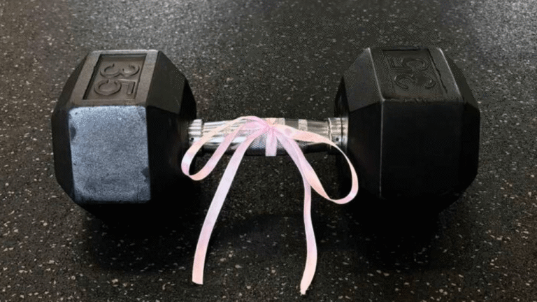 Halter preto com laço rosa no centro, simbolizando o início da jornada na musculação com foco em resultados.