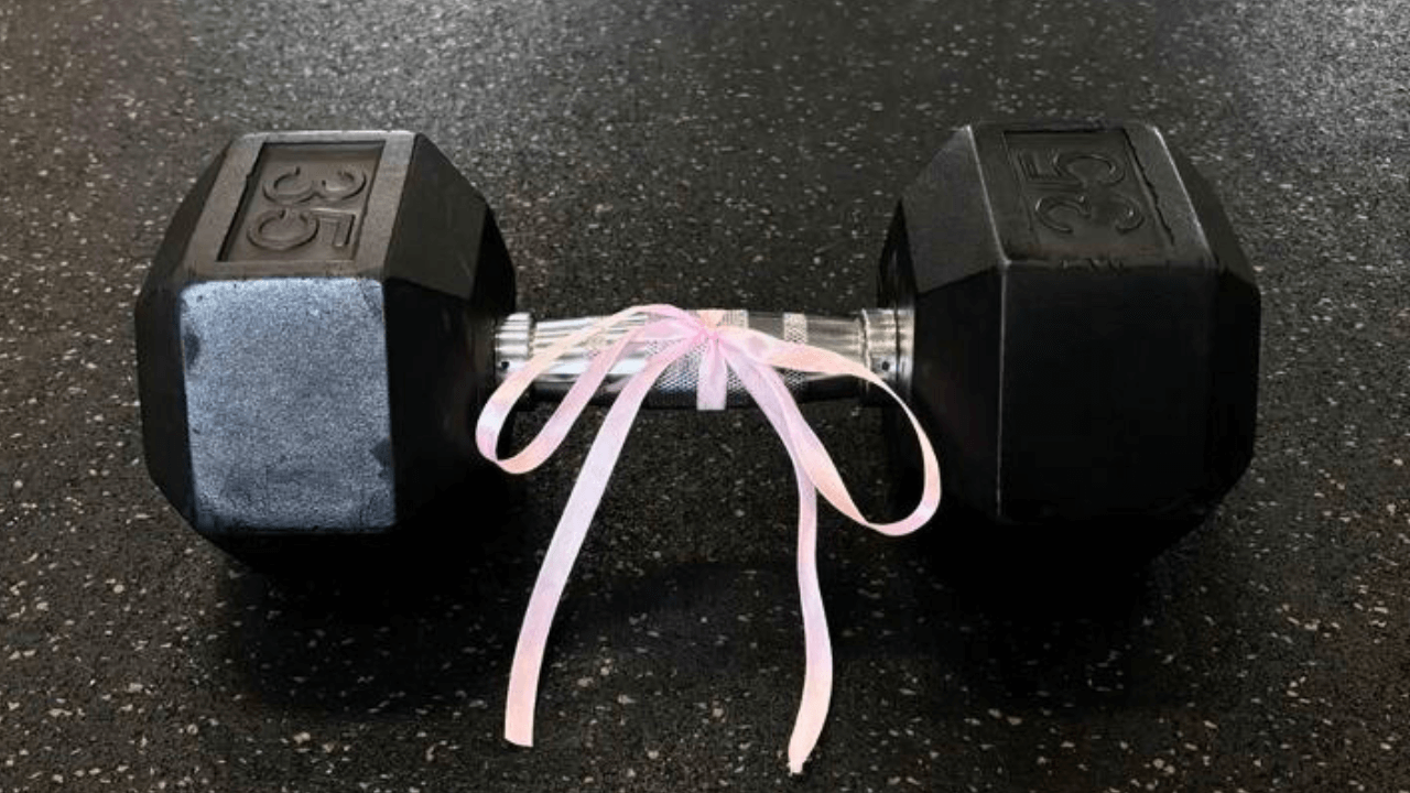 Halter preto com laço rosa no centro, simbolizando o início da jornada na musculação com foco em resultados.