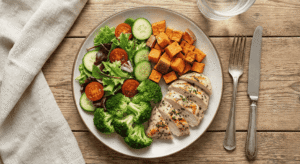 Prato de refeição saudável montado corretamente com a divisão de 50% vegetais, 25% proteína e 25% carboidrato.