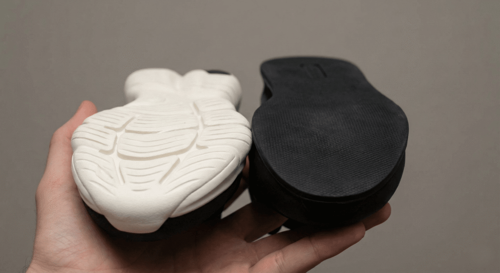 Detalhe comparando o solado macio de um tênis de corrida com o solado plano de um tênis de treino.