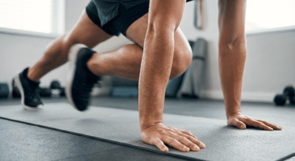 Detalhe do exercício Mountain Climber (alpinista) no chão.