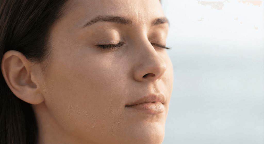  Rosto de mulher focado praticando a técnica de respiração quadrada para acalmar.
